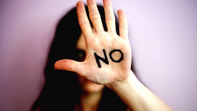 Una mujer con la inscripción en la mano: No